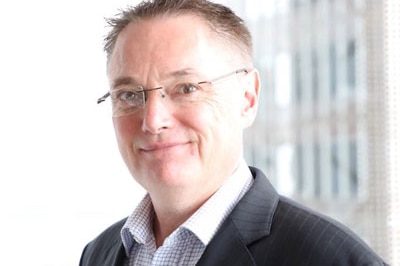 man in suit and glasses looking at the camera