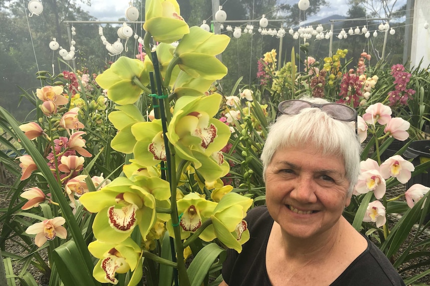 Sue Jones poses with an incredible bright green flowering orchid.