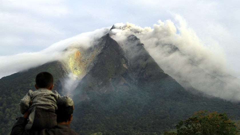 Man and son watch the erupting Sinabung volcano in Sumatra