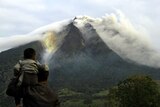 Man and son watch the erupting Sinabung volcano in Sumatra