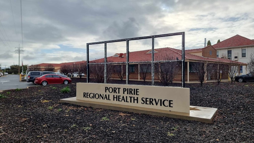 A sign that reads 'Port Pirie Regional Health Service' in front of a one-story building.