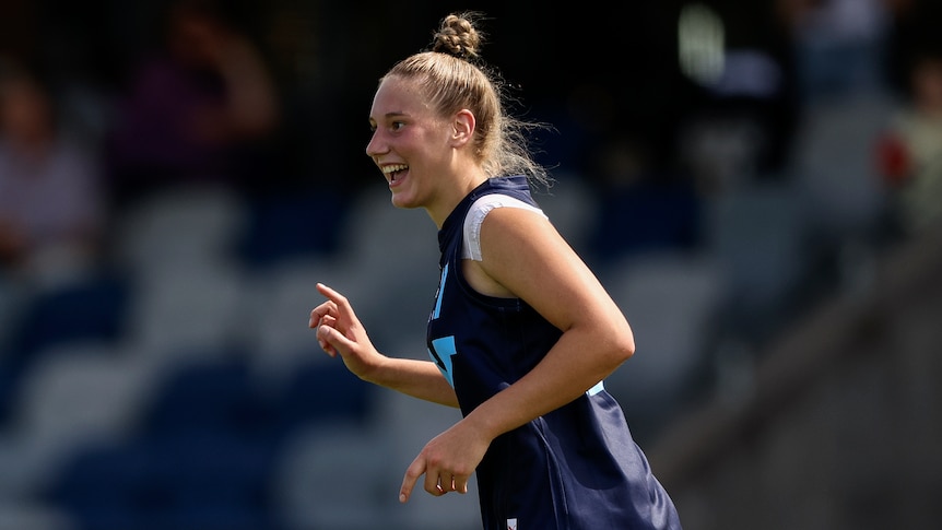 Montana Ham smiles as she runs during an under-18 AFLW game.