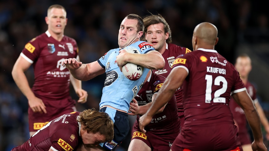 Isaah Yeo is tackled by three Maroons players