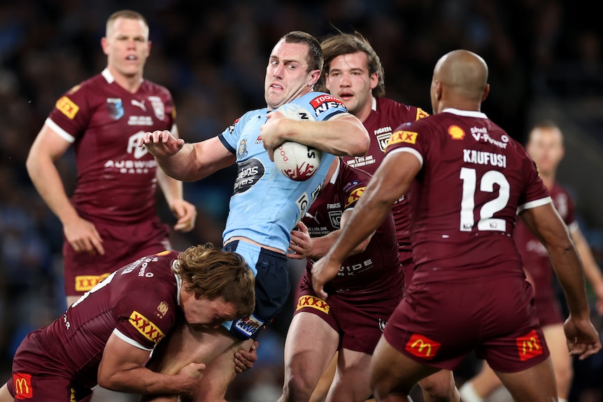 Isaah Yeo is tackled by three Maroons players