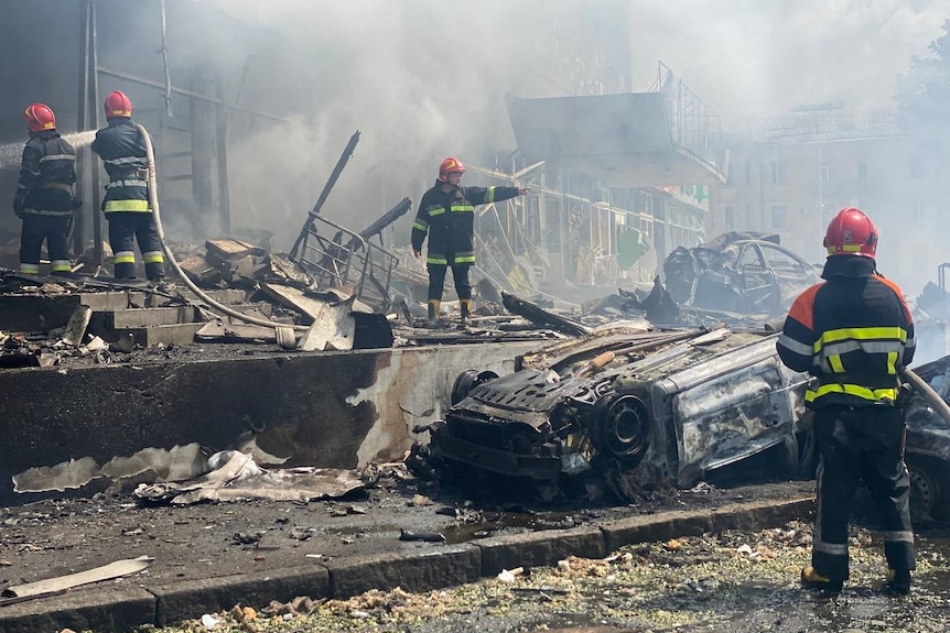 Firefighters work at the site of a Russian military strike