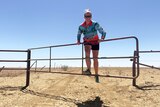 Woman swings on cattle gate in outback Queensland