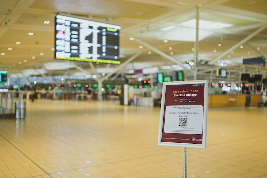 A check-in sign at the entrance with a deserted check-in area behind.