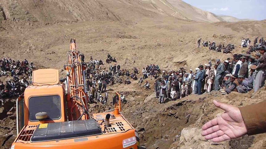 An excavator digs at the site of Afghan landslide