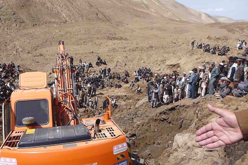 An excavator digs at the site of Afghan landslide