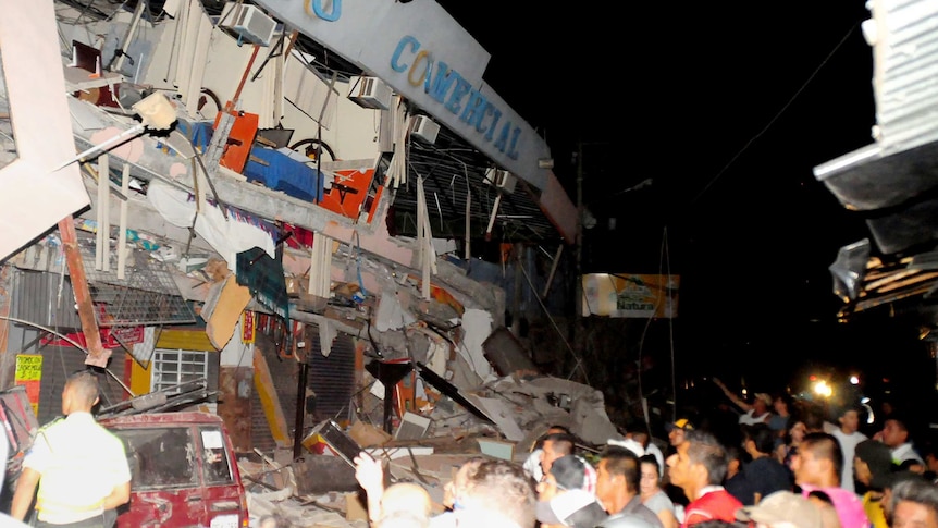 Rescue workers work to pull out survivors trapped in a collapsed building after a huge earthquake struck in the city of Manta.