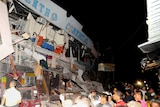 Rescue workers work to pull out survivors trapped in a collapsed building after a huge earthquake struck in the city of Manta.