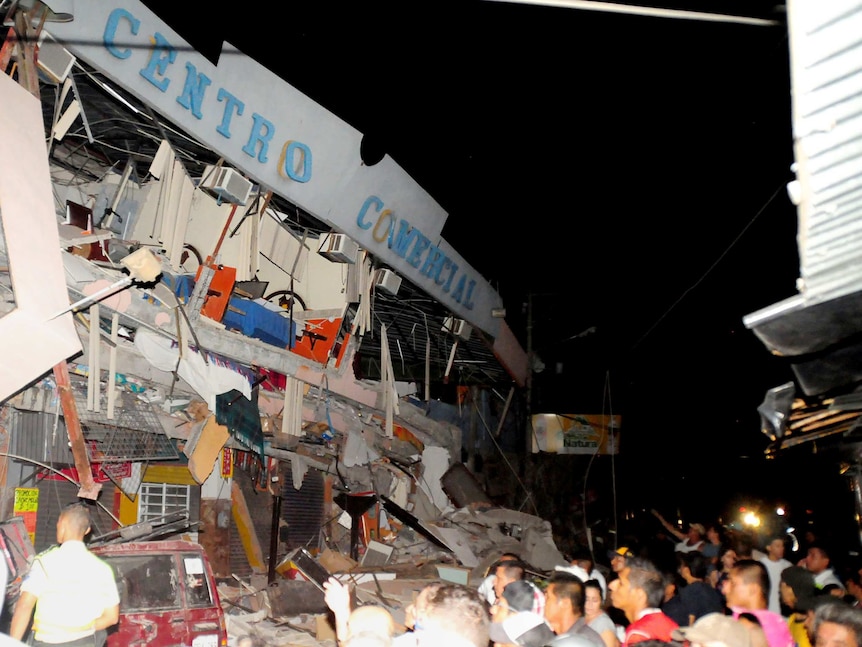Rescue workers work to pull out survivors trapped in a collapsed building after a huge earthquake struck in the city of Manta.