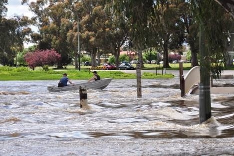 Two men in a boat on the flooded Lake Forbes