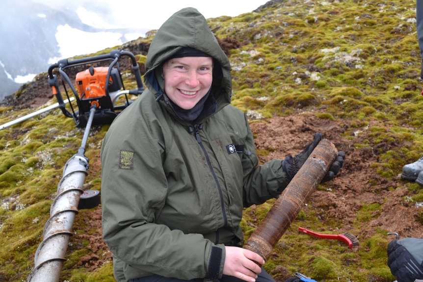 Team member Jessica Royles holds a frozen section of moss bank