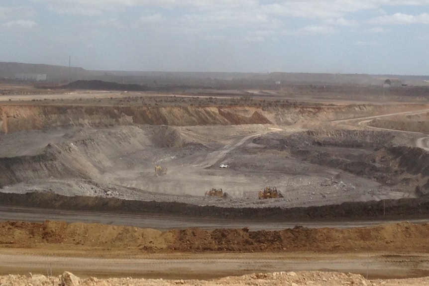 A coal mine with a pit surrounded by tracks.