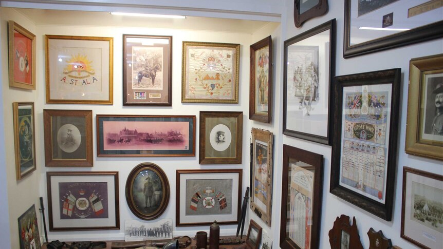 A corner of a room covered in pictures and historical artefacts.