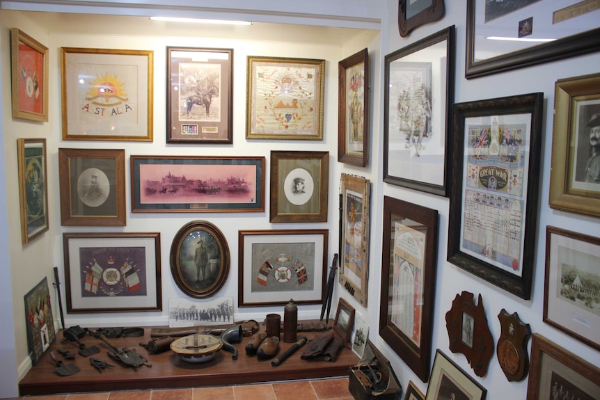 A corner of a room covered in pictures and historical artefacts.