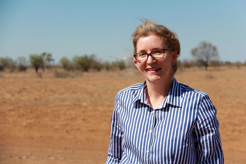 Barcaldine nurse Jane Williams stands in the drought-stricken landscape around Longreach.