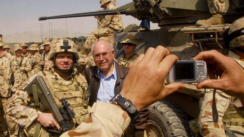 Former prime minister John Howard poses for photos with Australian soldiers