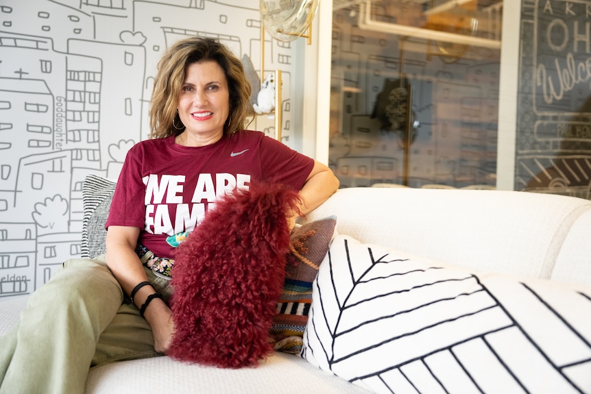 A woman sits on a couch.