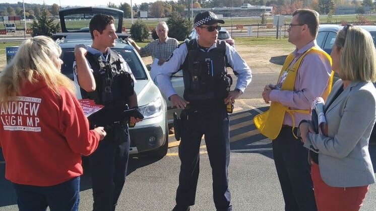 Two police officers speak to Katy Gallagher, and AEC official and a Labor volunteer.