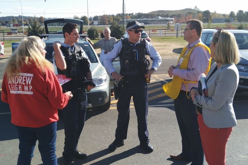 Two police officers speak to Katy Gallagher, and AEC official and a Labor volunteer.