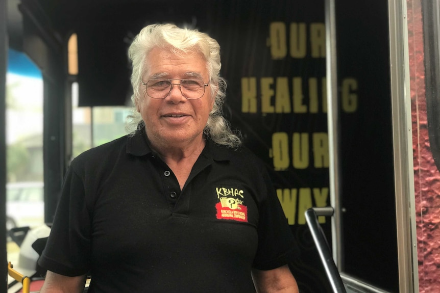 Uncle Roger Jarrett standing in the doorway of the bus in glasses and a black shirt