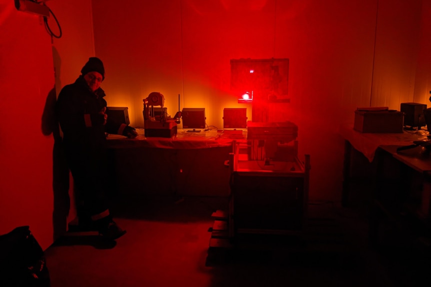 A researcher in a lab lit up with red light.