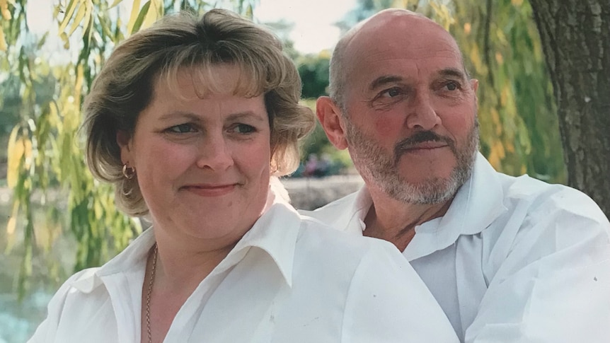 A woman and a man standing together outside both in white t-shirts