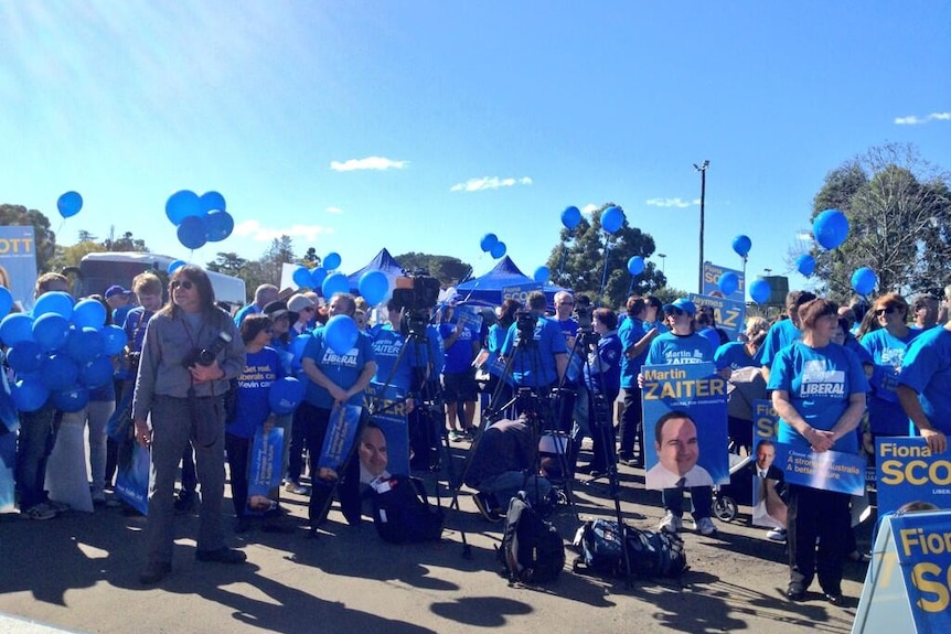Liberal Party supporters wait for the Tony Abbott western Sydney campaign bus to arrive at Penrith on August 13, 2013.