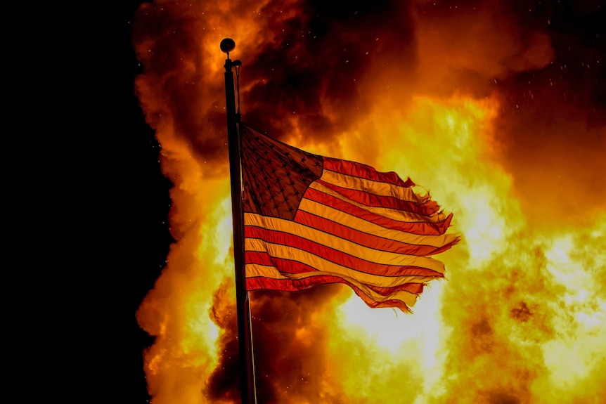 A burning US flag in the night sky