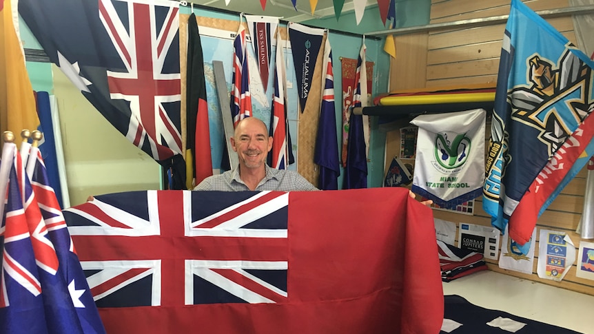 Gold Coast flag-maker Brad Palmer with a Cayman Islands Ensign flag