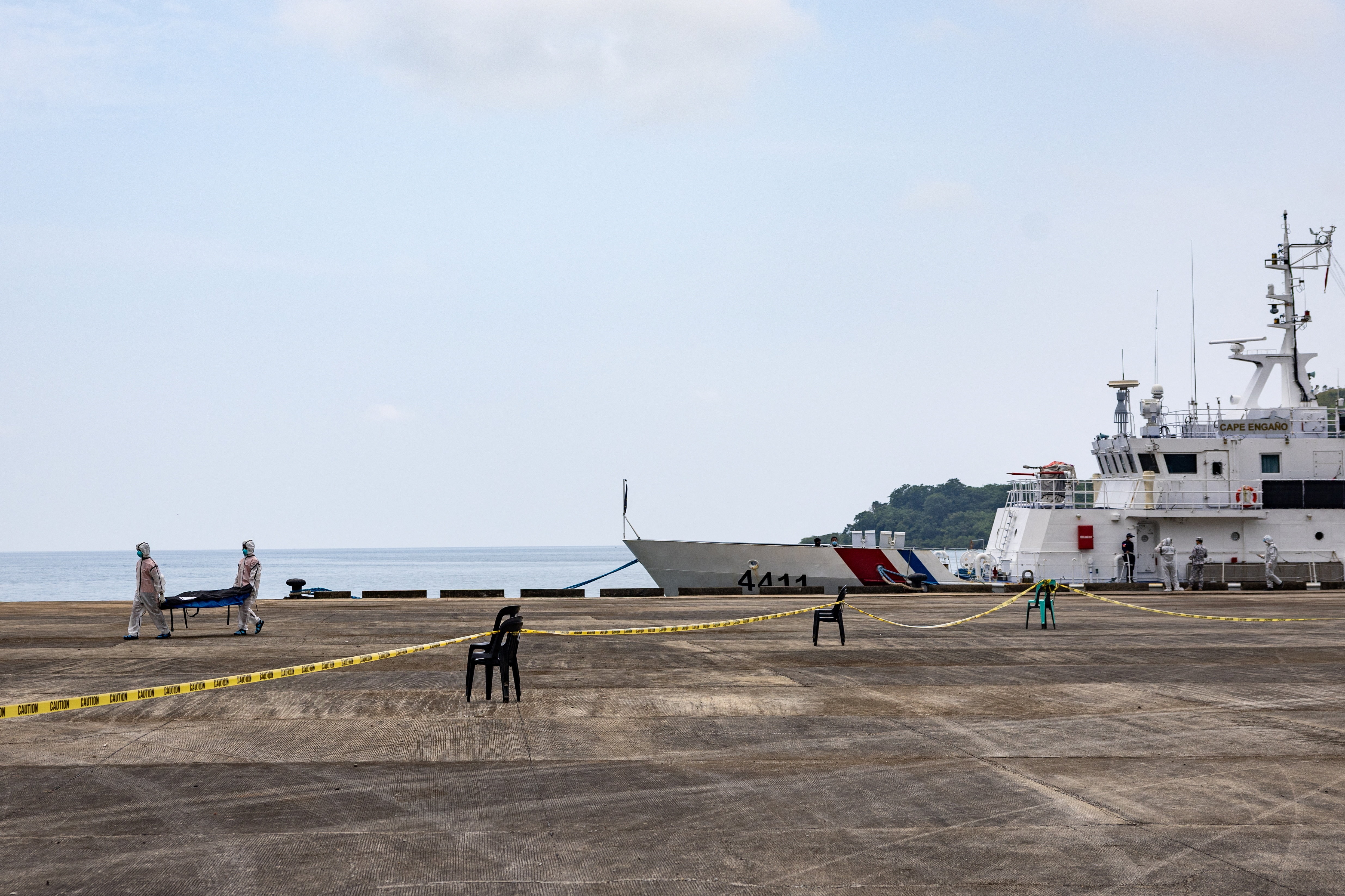 A view of a coast guard ship docked, with a cordoned-off area seen in the foreground