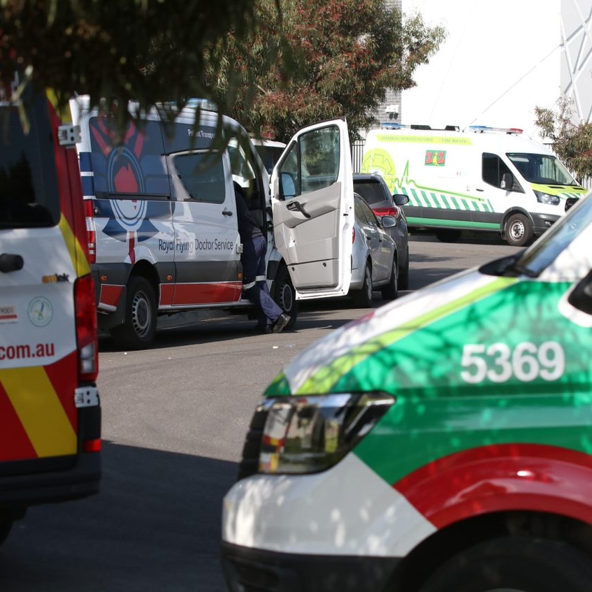 Ambulances are parked in a row along a driveway outside the Epping Gardens aged care home.