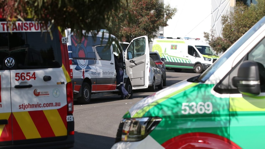 Ambulances are parked in a row along a driveway outside the Epping Gardens aged care home.