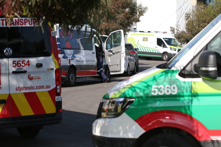 Ambulances are parked in a row along a driveway outside the Epping Gardens aged care home.