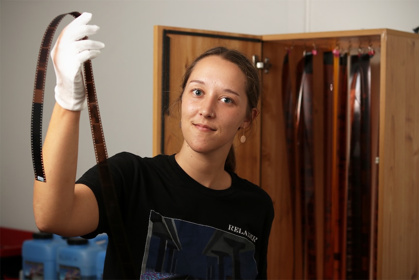 Kelsey Hopkins hold a film negative in her film developing lab in Wollongong.