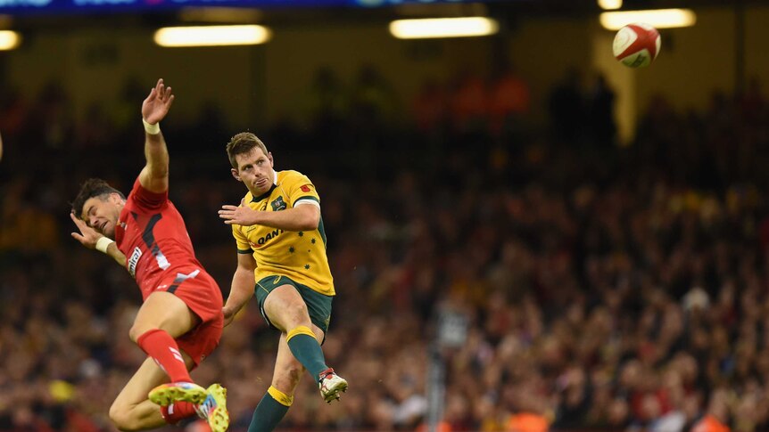 Ice man ... Bernard Foley lands a drop goal despite the attention of Mike Phillips