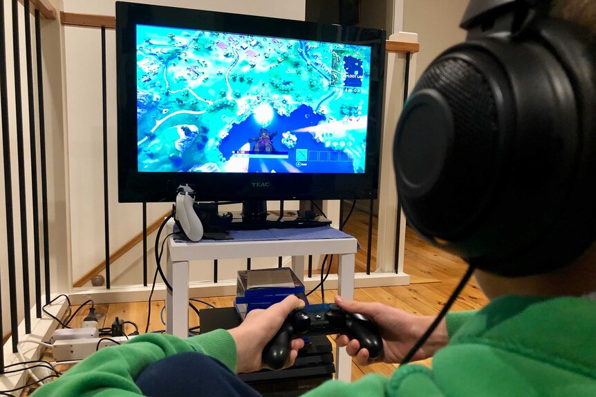 A child sits in front of a television playing a video game.