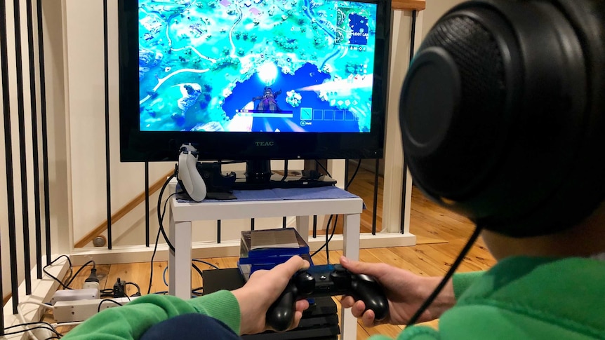 A child sits in front of a television playing a video game.