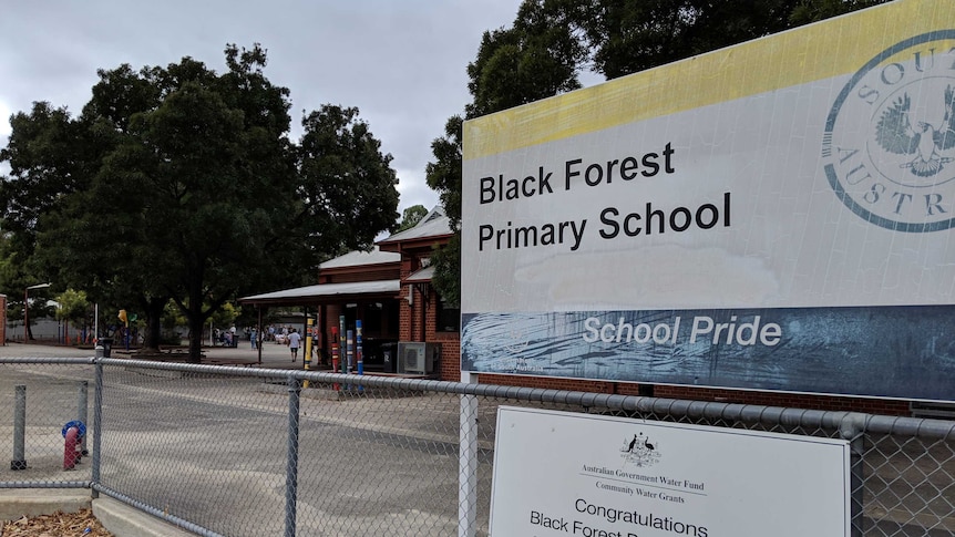 A fence and sign outside a primary school.