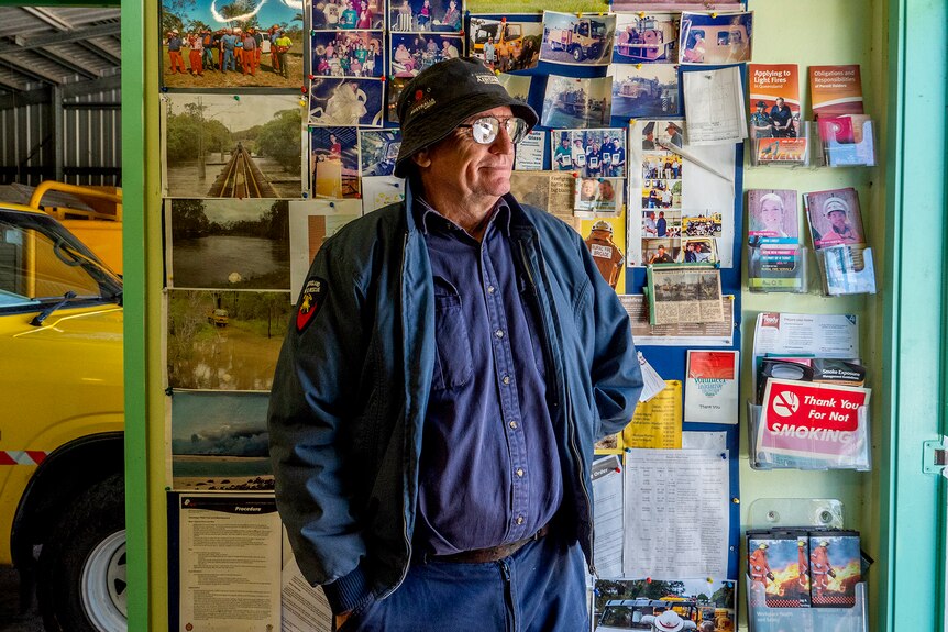 A man stands in front of a photo wall.