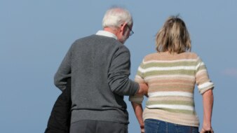 An older man assists a younger woman on crutches (Getty Images: Thinkstock)