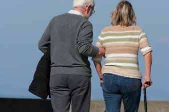 An older man assists a younger woman on crutches (Getty Images: Thinkstock)