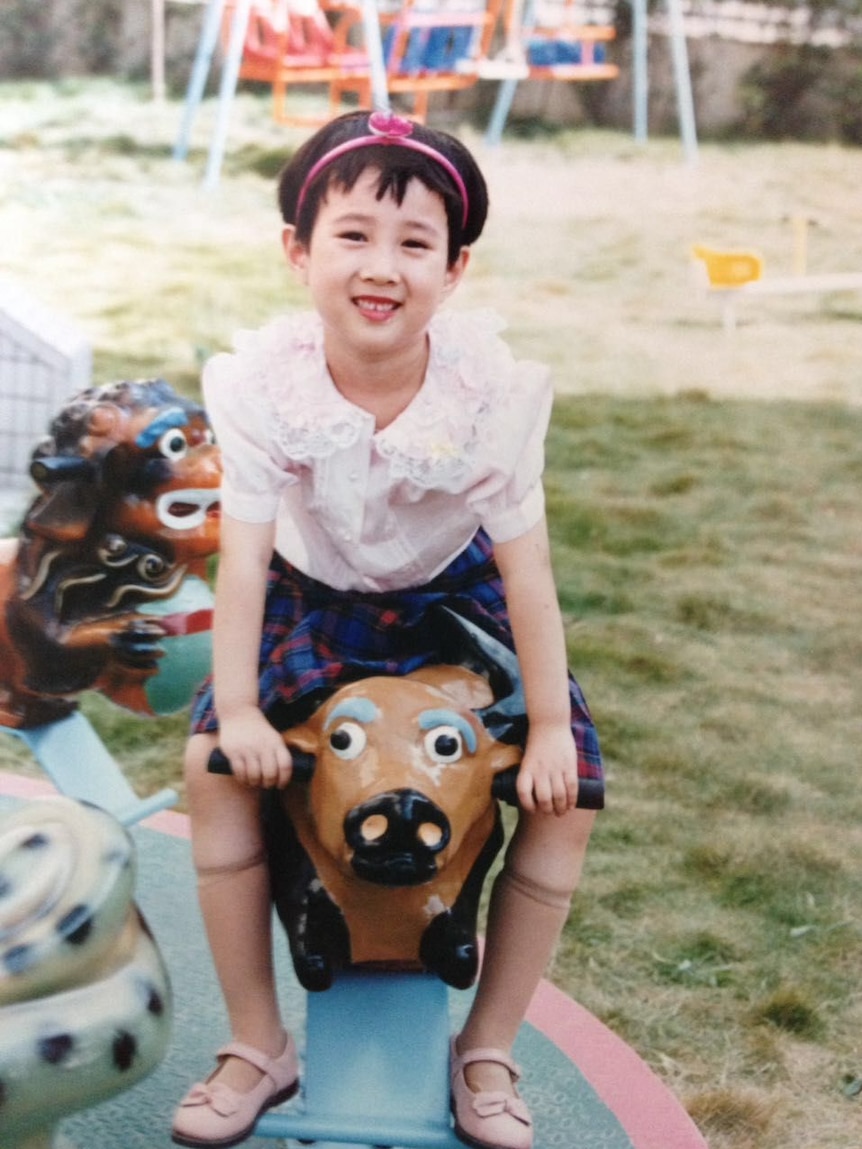 Christina Zhou sits on a children's ride in China.