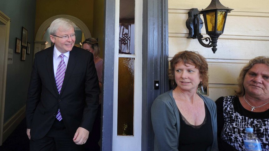 Nurses sit outside a Medicare Local in Lismore as Kevin Rudd walks out the door