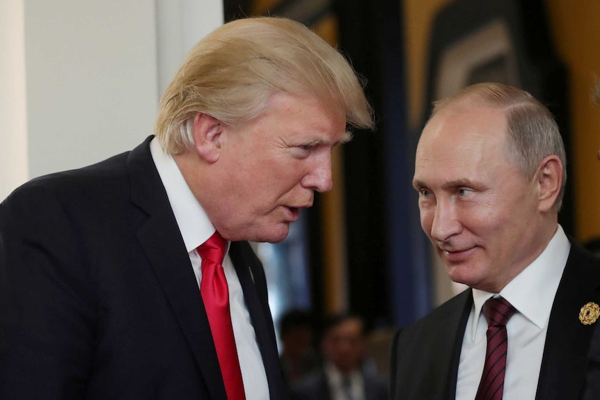 US President Donald Trump talking to a smiling Russian President Vladimir Putin.