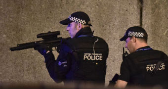An armed police officer looks through his weapon on London Bridge in London.