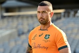 Quade Cooper stands with his thumbs in his shorts in an empty stadium