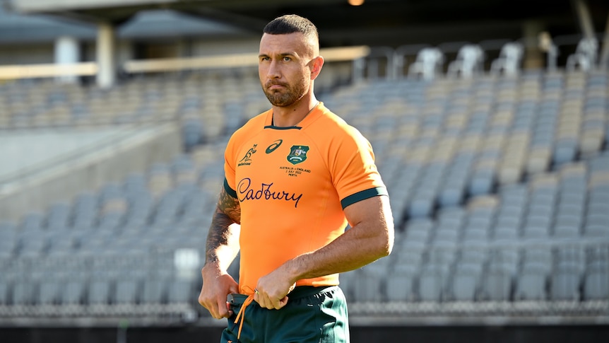 Quade Cooper stands with his thumbs in his shorts in an empty stadium